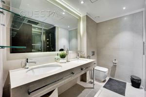 y baño con lavabo, espejo y aseo. en Marina Promenade, Dubai Marina, en Dubái