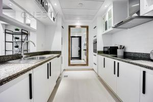 a kitchen with white cabinets and a sink at Marina Promenade, Dubai Marina in Dubai