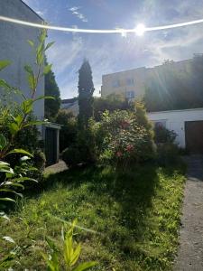 een tuin met planten en een gebouw en de zon bij Domek nad morzem in Sopot