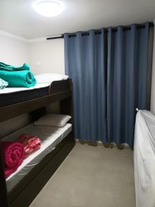 a room with two bunk beds and a blue curtain at Arriendo Diario En La Playa Sector Casino ENJOY in Coquimbo