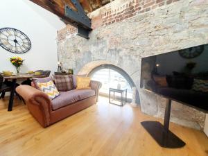 a living room with a couch and a fireplace at Royal William Yard - Lovely 1-Bed Apartment in Historic Plymouth in Plymouth