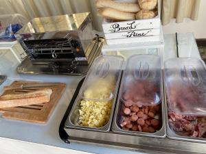 un mostrador con bandejas de diferentes tipos de alimentos en Zia Bi Bed and Breakfast en Nápoles