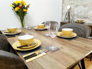 uma mesa de madeira com pratos e copos e um vaso de flores em Royal William Yard - Lovely 1-Bed Apartment in Historic Plymouth em Plymouth