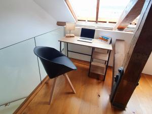 an attic room with a desk with a laptop on it at Royal William Yard - Lovely 1-Bed Apartment in Historic Plymouth in Plymouth