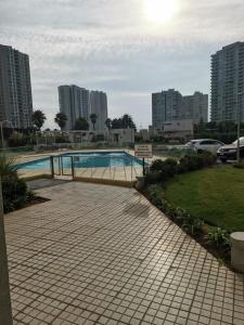 a swimming pool in a city with tall buildings at Arriendo Diario En La Playa Sector Casino ENJOY in Coquimbo