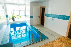 a swimming pool in a bathroom with blue tiles at Hotel Sofia in Polatsk