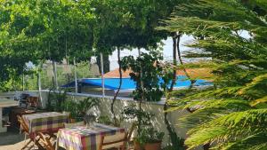 a patio with tables and chairs and a swimming pool at Guesthouse Lidija in Sutivan