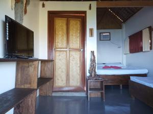 a room with a door and a bed and a television at OcamOcam Azur Inn in Busuanga