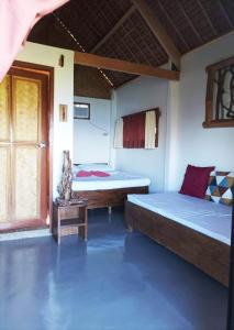 Habitación con 2 camas y ventana en OcamOcam Azur Inn en Busuanga