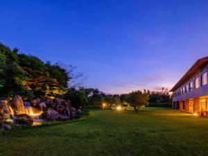a night view of a building and a yard at SPA HOTEL YUTTARIKAN in Satsumasendai