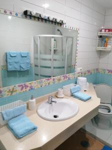 Un baño con lavabo, espejo e inodoro. en la siesta 23D, en Benidorm