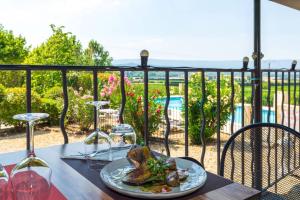 una mesa con un plato de comida y copas de vino en Vilajoun, en Joucas