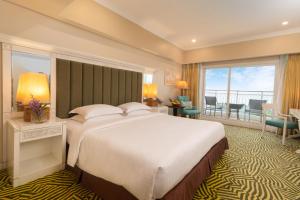 a hotel room with a large bed and a balcony at Jpark Island Resort & Waterpark Cebu in Mactan