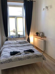 1 cama blanca en un dormitorio con ventana en Zamojska, en Lublin