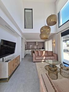 Luxury Villa by NRAS في غران ألاكانت: غرفة معيشة مع أريكة وتلفزيون