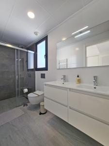 La salle de bains blanche est pourvue de toilettes et d'un lavabo. dans l'établissement Luxury Villa by NRAS, à Gran Alacant