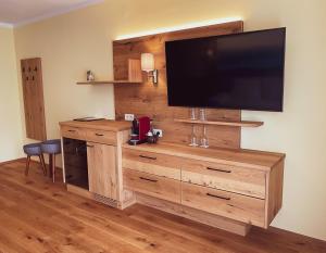a large wooden entertainment center with a flat screen tv at Hotel Kärnten in Krumpendorf am Wörthersee