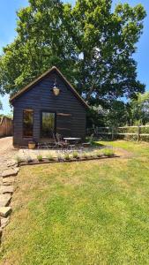 a small house with a picnic table in a yard at Gatwick hideout in Charlwood