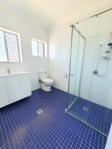 a bathroom with a toilet and a glass shower at Maria Motel in Moree