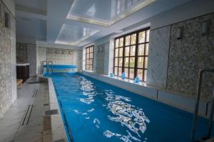 a large swimming pool with blue water in a room at Hotel Rytwiany in Rytwiany