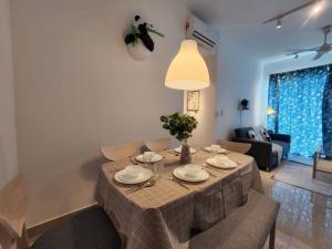 a table in a living room with a dining room at 10pax Cinema Themehouse 3B2R with pool sauna atari games,wifi in Shah Alam