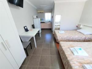 a room with two beds and a desk and a kitchen at Maria Motel in Moree