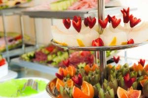 a three tiered display of cakes and fruit at Hotel Des Artistes in Rome