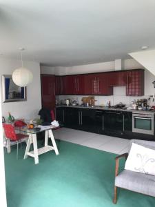 a kitchen with red cabinets and a green floor at Lake Street Accommodation in Oxford