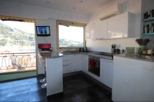a kitchen with white cabinets and a large window at Excellent location - Sea Views in Villefranche-sur-Mer