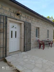 a patio with a white door and a table at Vikendica Ćurić in Trebinje