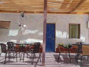 uma sala com mesas e cadeiras e uma porta azul em Hostal Siete Colores em San Pedro de Atacama