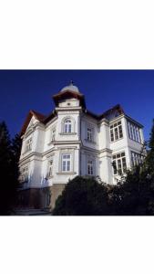 un gran edificio blanco con una torre de reloj en Villa Reder, en Bad Sauerbrunn