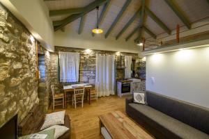 a living room with a stone wall and a couch at Kalochori Luxury Cottage 