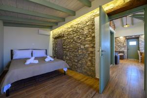 a bedroom with a bed and a stone wall at Kalochori Luxury Cottage 