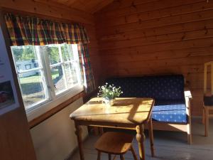 a room with a table and a bench in a cabin at Lesjaskogsvatnet Camping in Lesjaskog