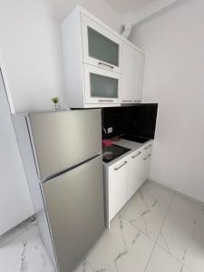 a white kitchen with a refrigerator and a microwave at Villa Denis Ksamil in Ksamil