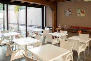 a restaurant with white tables and white chairs at La Dimora Dei Mori in Acitrezza