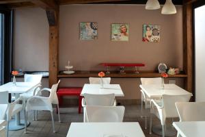 a restaurant with white tables and white chairs at La Dimora Dei Mori in Acitrezza