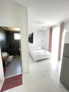 a white room with a bed and a bathroom at Villa Denis Ksamil in Ksamil