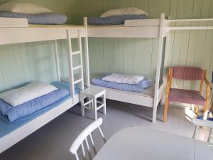 a room with bunk beds and a table and a chair at Lesjaskogsvatnet Camping in Lesjaskog