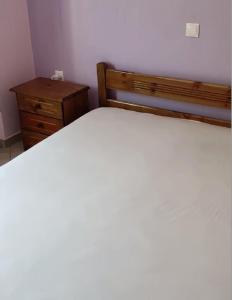 a bedroom with a bed and a wooden dresser at Paganatos Place in Sívros