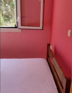 una camera rossa con letto e finestra di Paganatos Place a Sívros