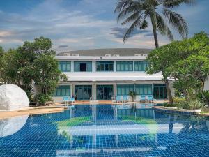 a swimming pool in front of a building at Sand Sea Resort & Spa - Lamai Beach , Koh Samui in Lamai