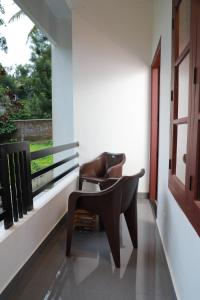 a chair and a desk in a room with a window at Wanderlust Residence Homestay in Thekkady +2 photos