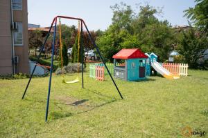 a playground with swings in a yard at Villa Orange in Sozopol