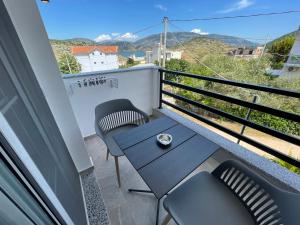 a balcony with chairs and a table with a view at Villa Denis Ksamil in Ksamil