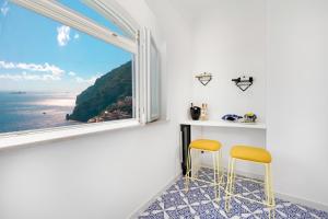 Habitación con mesa, 2 sillas y ventana en Casa Lou Positano, en Positano