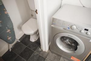 a small bathroom with a washing machine and a toilet at Green Park house in Leicester
