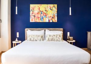 una camera da letto con un grande letto bianco con una parete blu di Iasonos Suites Athens ad Atene