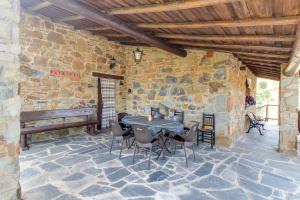 een patio met een tafel en stoelen in een stenen muur bij Casa Rural Manantío Blanco in Valverde del Fresno